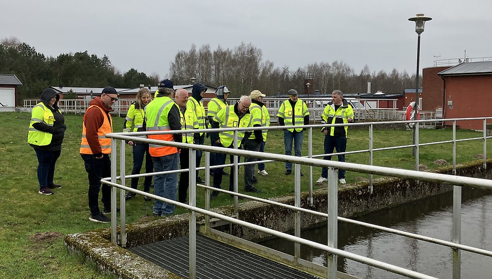 Tekniska nämndens politiker tittar i en av reningsbassängerna på Sjöbo avloppsreningsverk