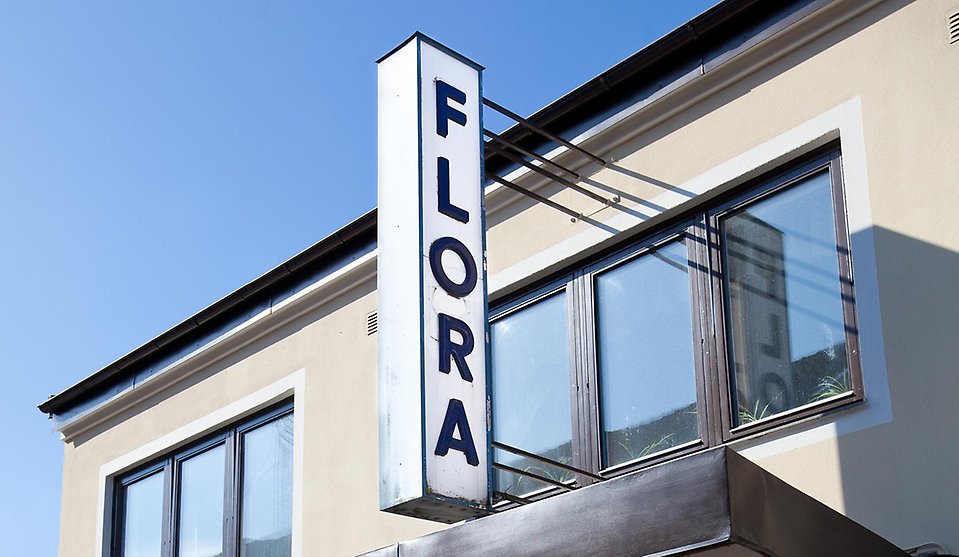 Flora's skylt mot blå himmel