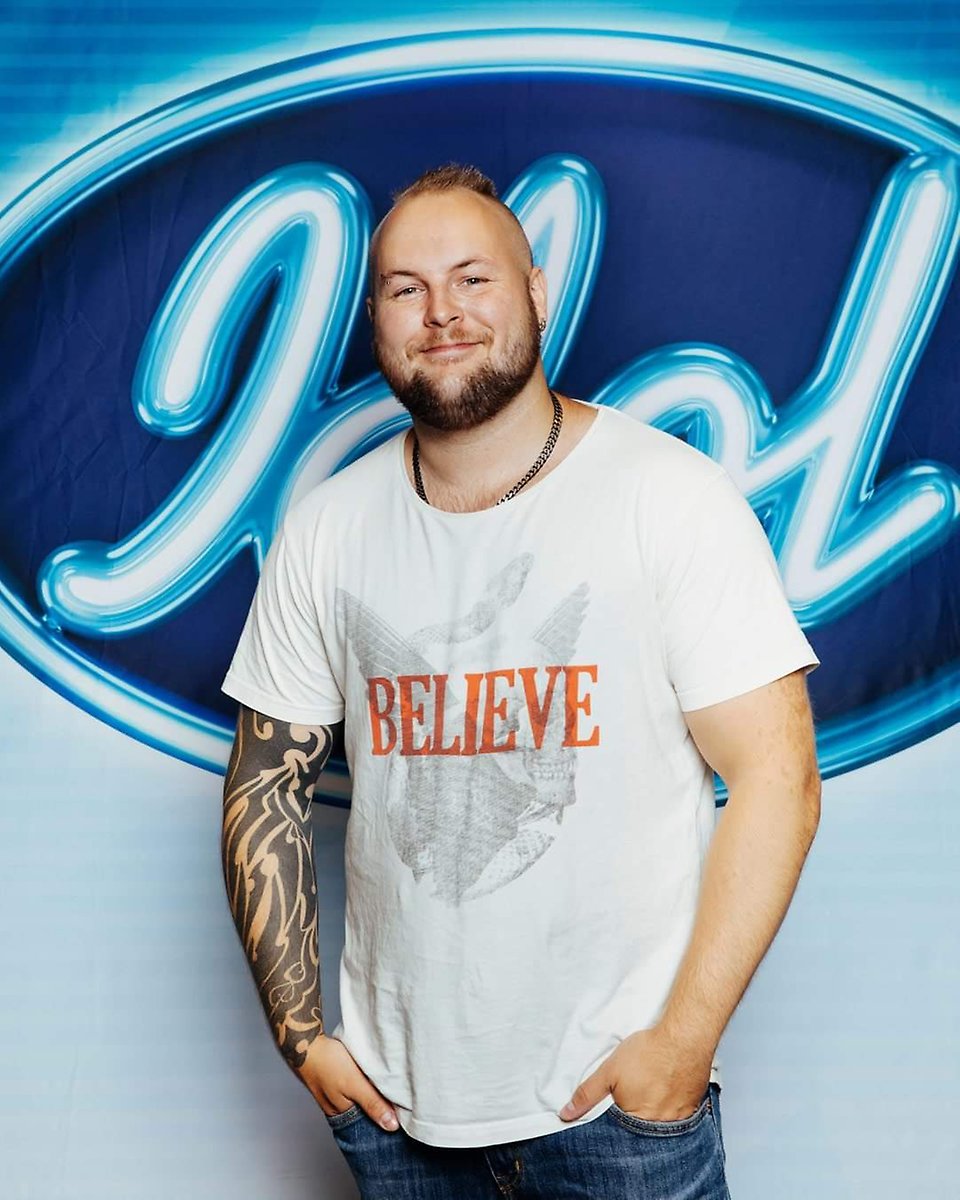 Porträttfoto av Mattias Nederman framför tvprogrammet Idols logga