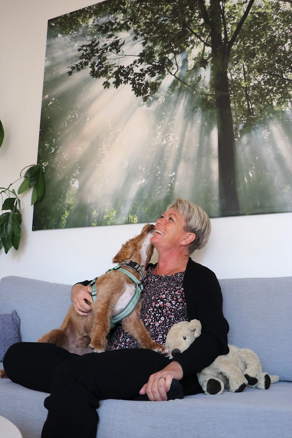 Annica Otterman och labradooldetiken Chilly som är en social tjänstehund och arbetar på Sjöbo kommuns HR-avdelning, sitter i soffan och myser.