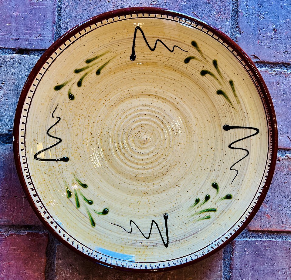 En bild på ett keramikfat med grönt mönster på, fotograferat uppifrån.